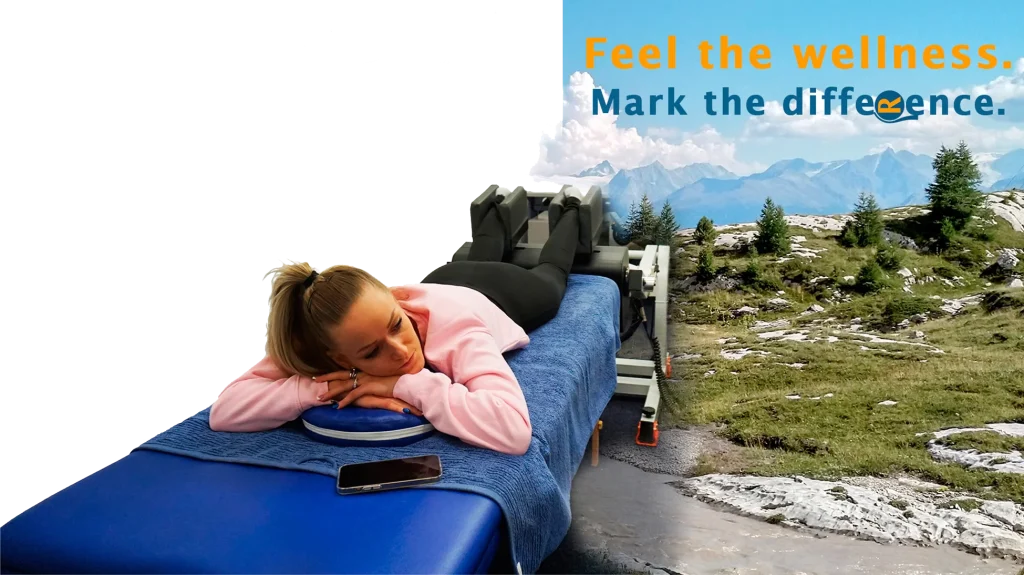 Persona recostada sobre una camilla utilizando el dispositivo MRM Wellness, con paisaje montañoso al fondo y el lema “Feel the wellness. Mark the difference.”