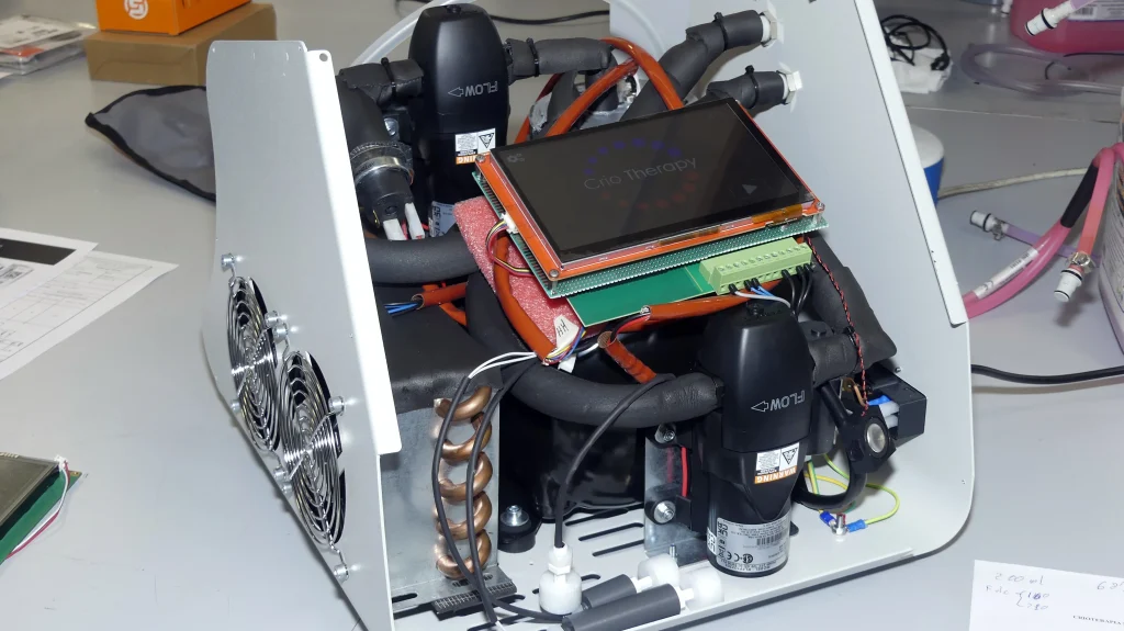 Intérieur d'une unité de cryothérapie en cours de développement, comprenant des composants électroniques, un circuit de commande et un système de thermostat à fluide.