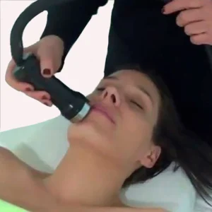 Person receiving facial treatment with a manual applicator that applies cold or heat to the chin area.